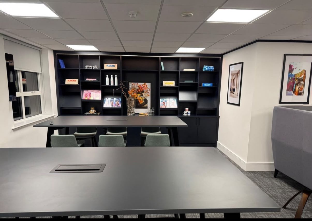 Commercial office joinery with dark fitted shelving and a long fitted desk installed by MJS Bespoke Joinery