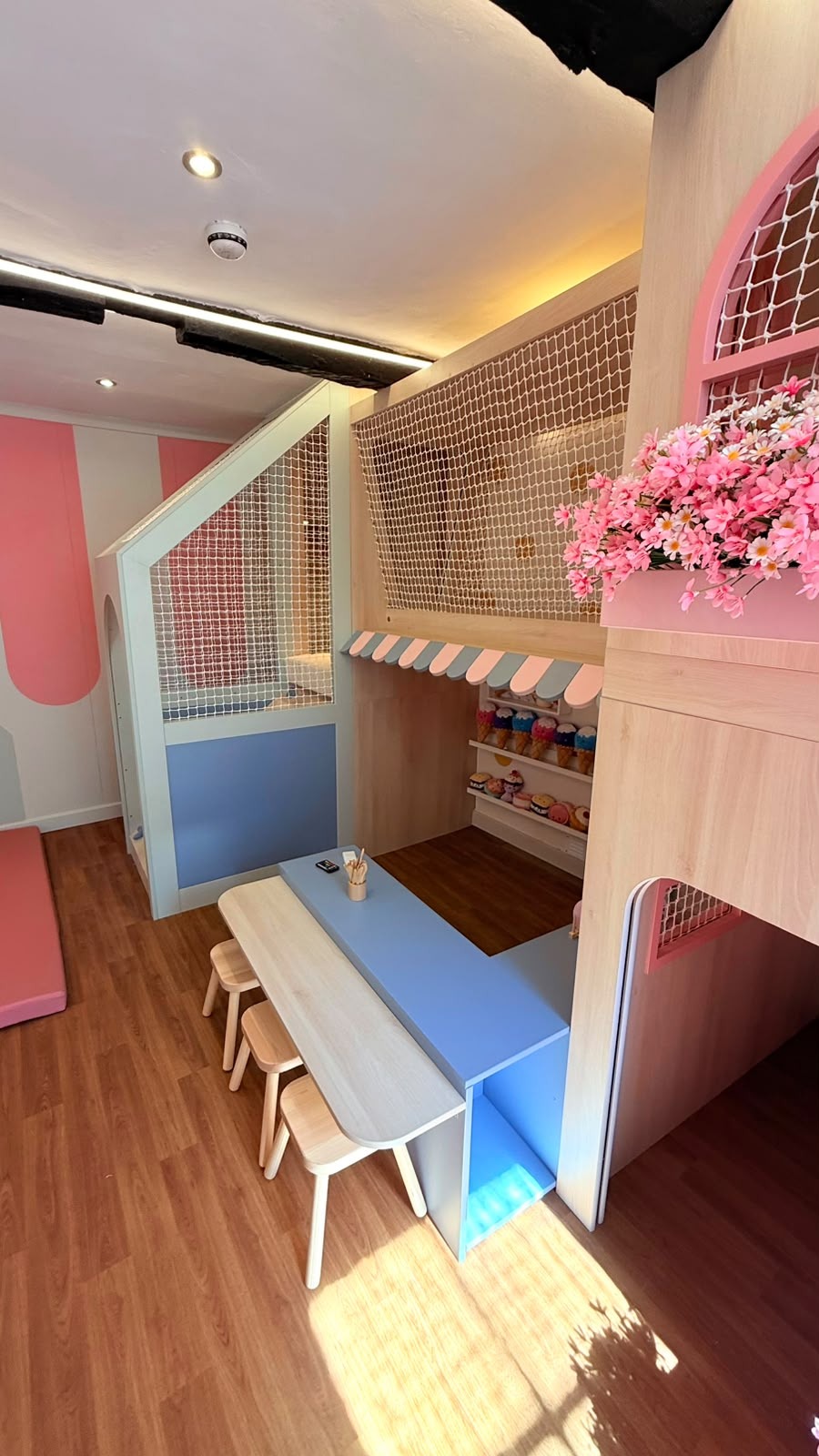 Bespoke children's playroom with a built-in timber play structure, seating and storage